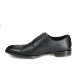 A black vegan leather men's dress shoe with a cap toe. Slightly tapered toe. Lace up with 5 eyelets. Black lining and sole.